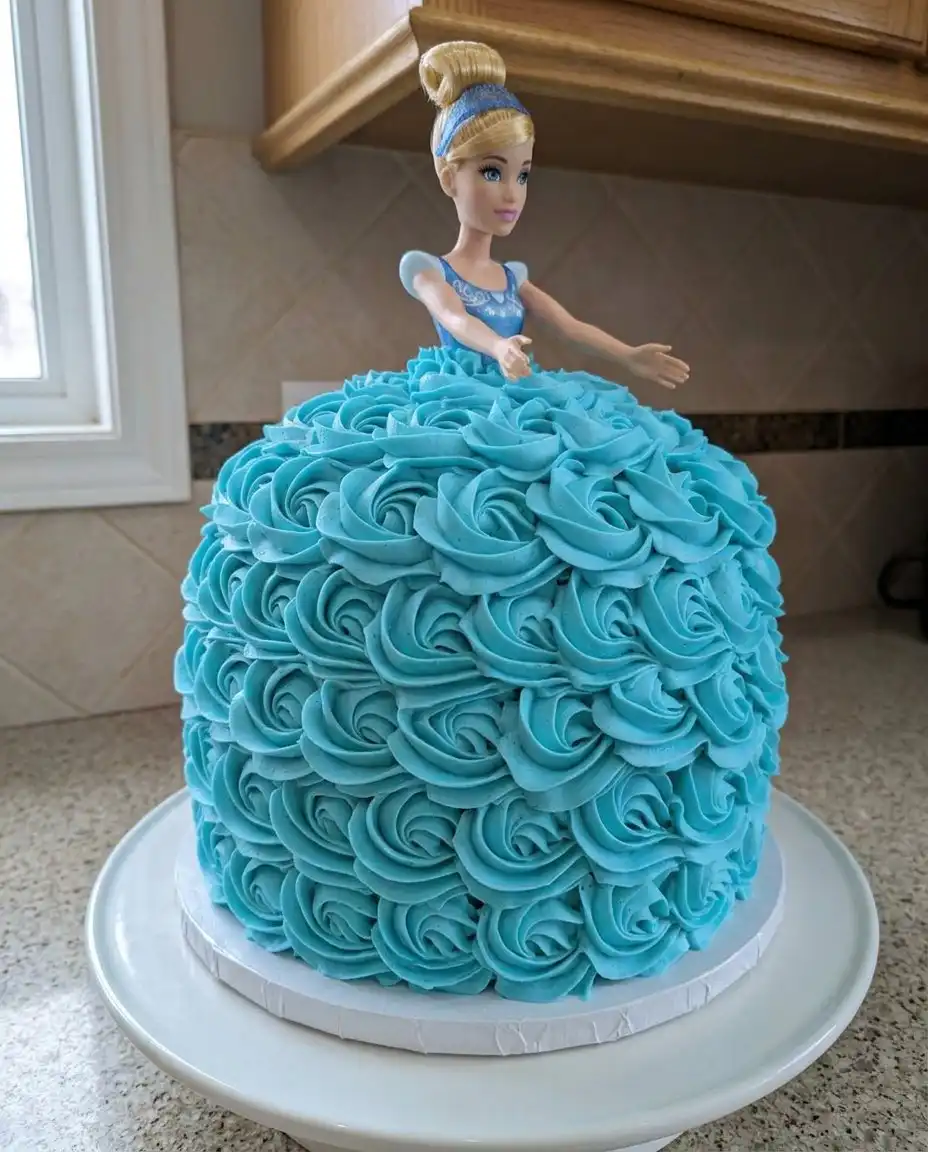 A tall slice of blue rosette cake on a white china plate