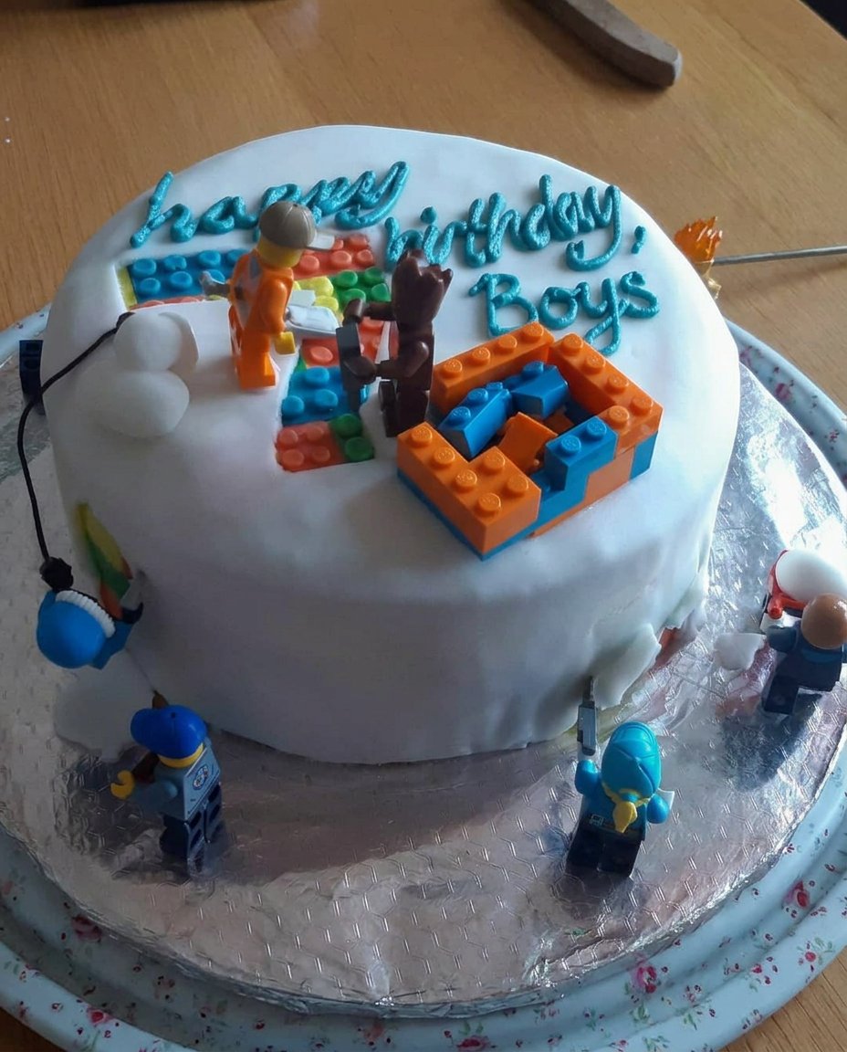 A square slice of green soccer cake being served on a plate with a fork