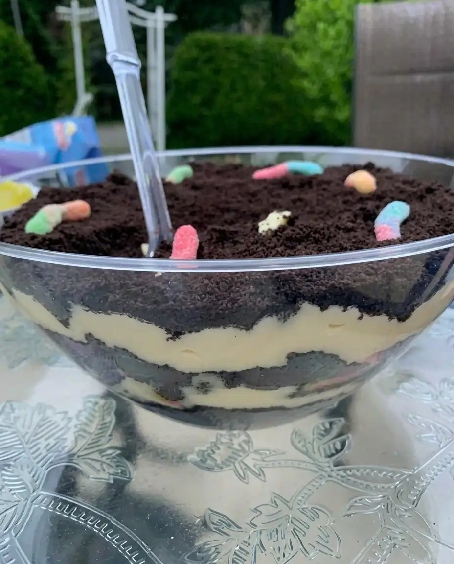 Individual servings of Easter dirt cake in clear glass jars with candy toppings