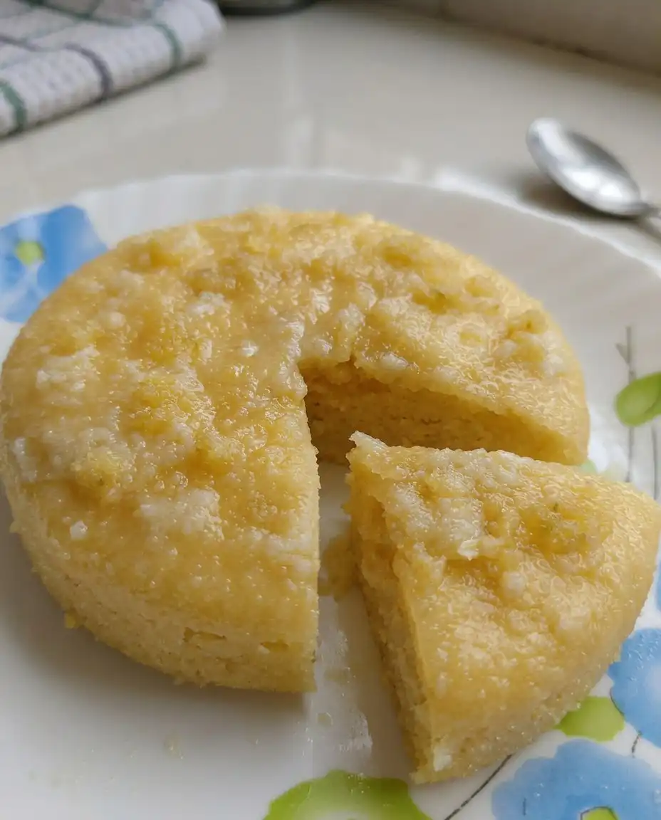 A hand using a wooden skewer to poke holes in a warm lemon cake