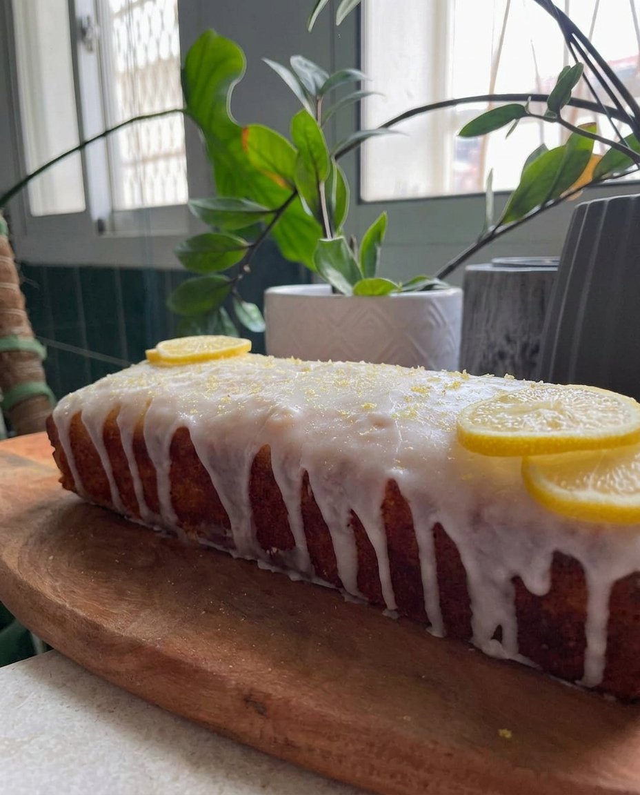 A slice of lemon cake showing four layers and filling on a lace doily