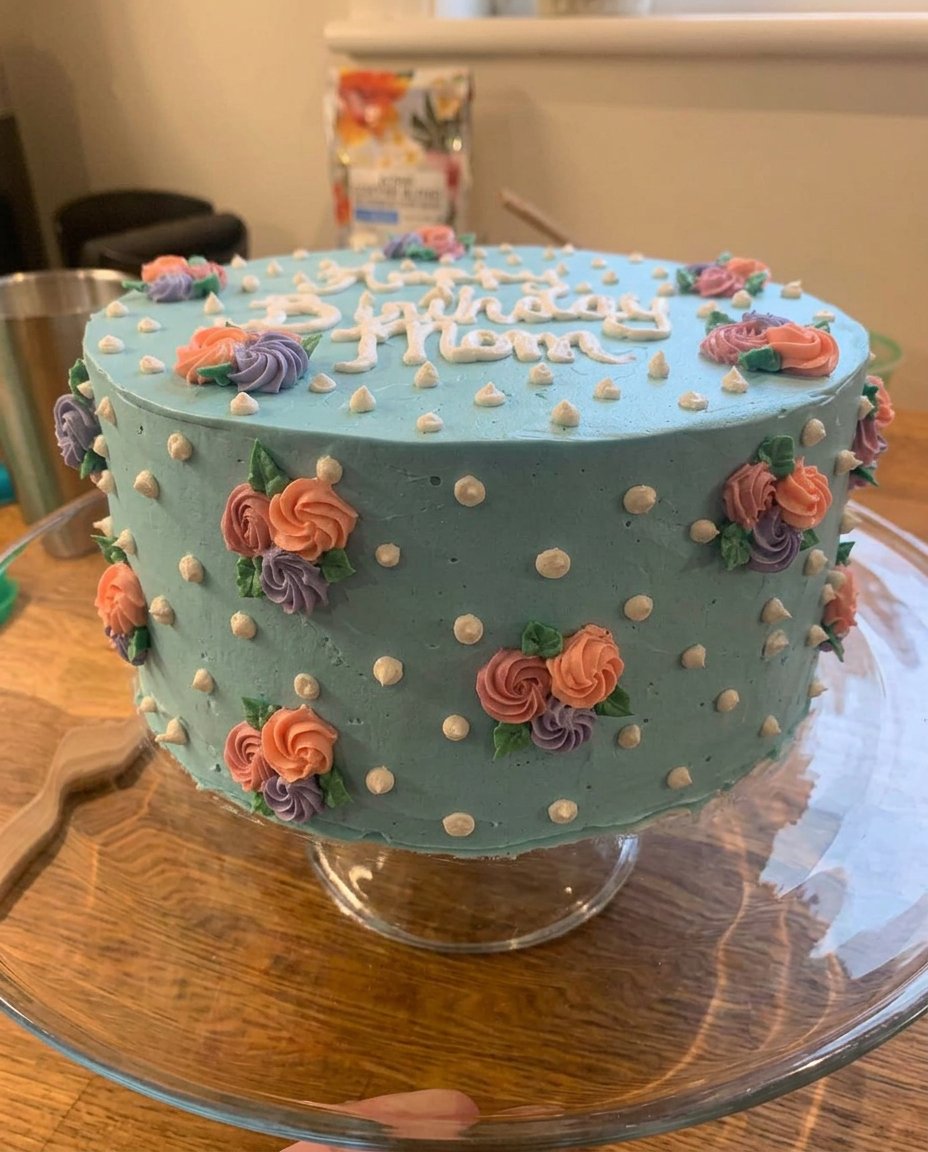 Close up of a tapered spatula creating a white icing rose petal
