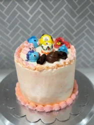 A three-layer vanilla cake with purple buttercream frosting and sprinkles inspired by BTS