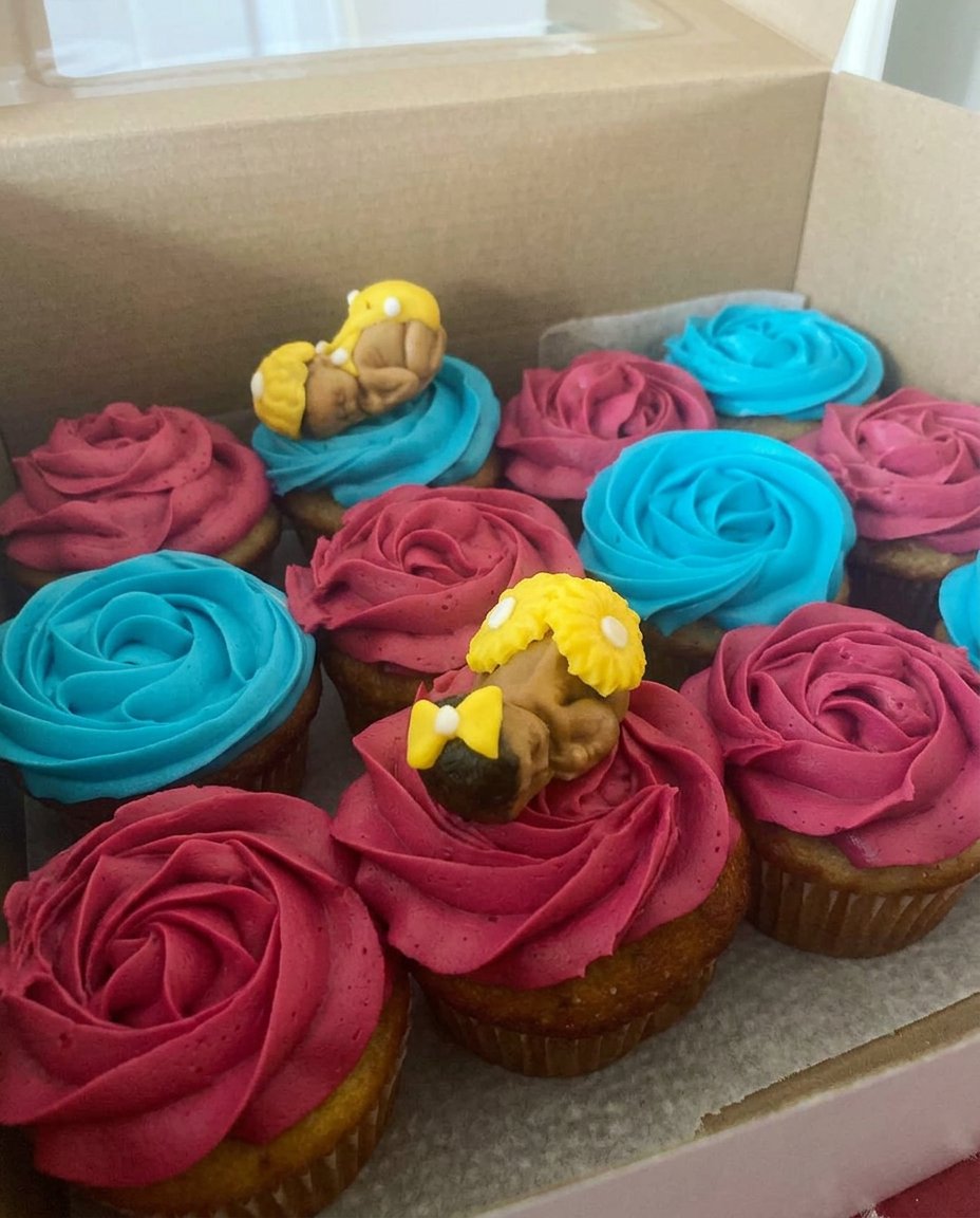 A close up of hand piped chocolate cake toppers shaped like stars and letters resting on waxed paper.