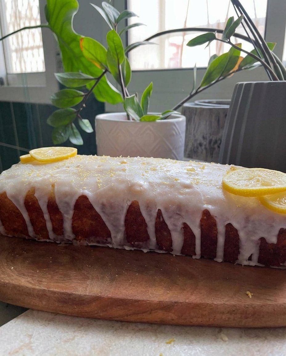 A four layer lemon cake with yellow filling on a vintage glass pedestal stand