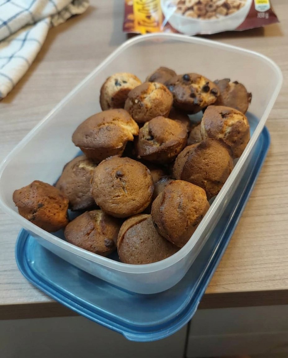 A three layer strawberry chocolate cake with pink frosting and chocolate ganache on a glass stand