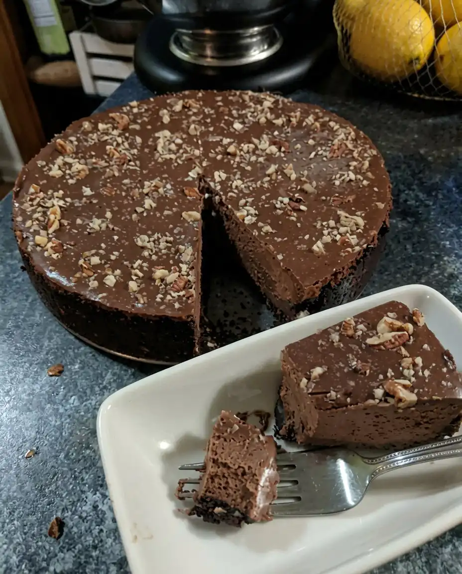 A close up view of a sliced chocolate truffle cake showing the dark sponge and whipped truffle layer