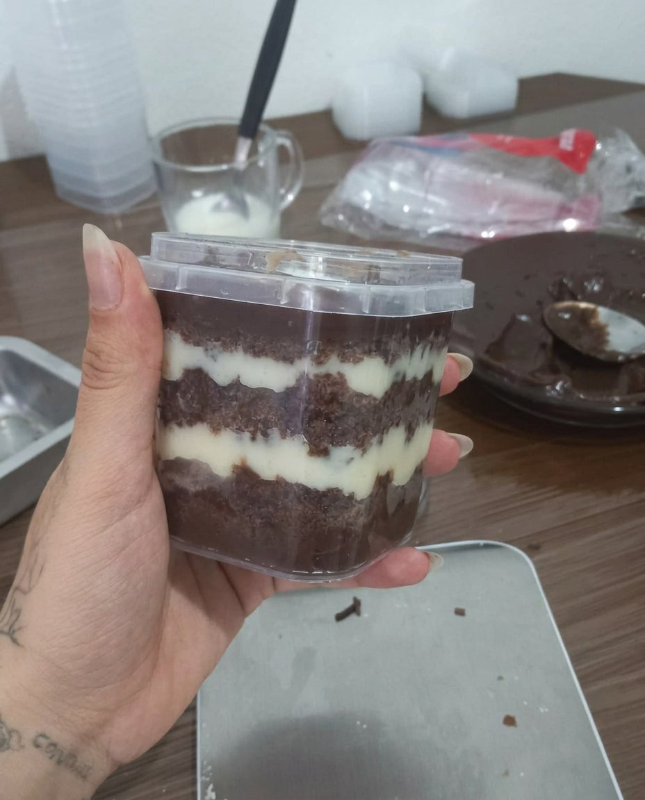 A finished jar cake on a white saucer with a silver spoon