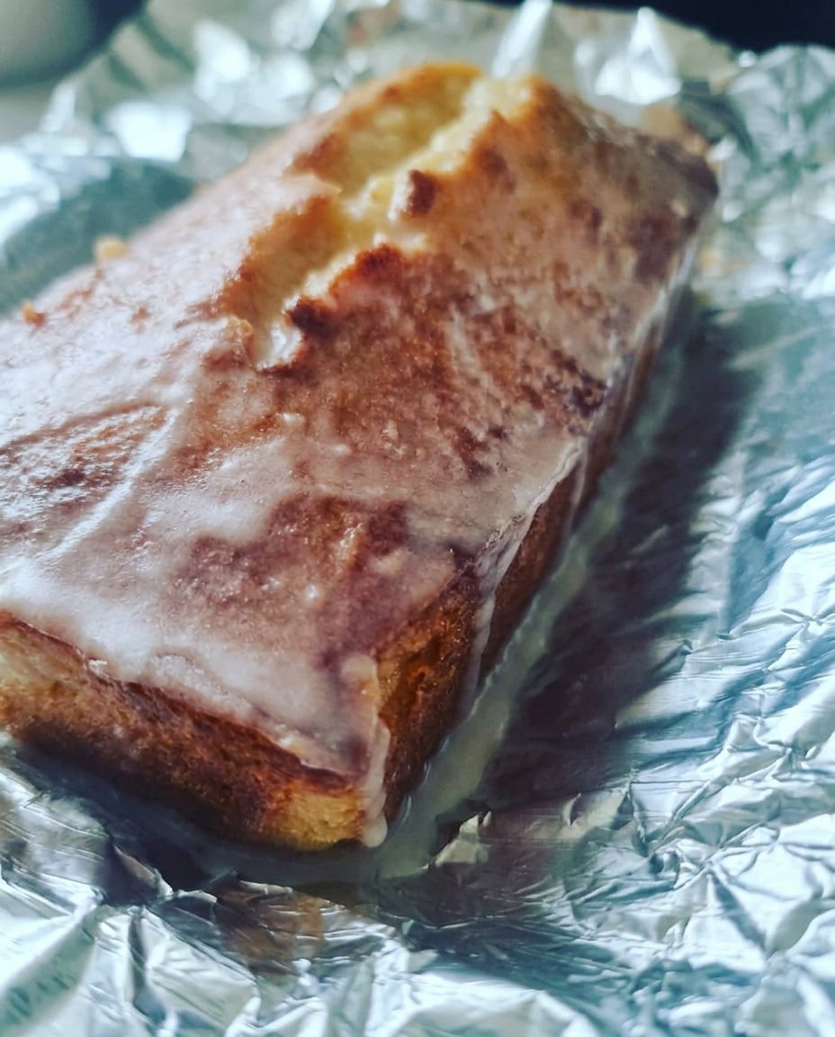 Lemon Drizzle Cake 12 Baking ingredients including fresh lemons, a bowl of flour, and eggs on a rustic wooden table
