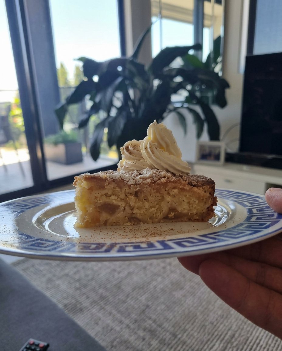 A thick, glossy brown cake batter being mixed in a glass bowl with a wooden spoon