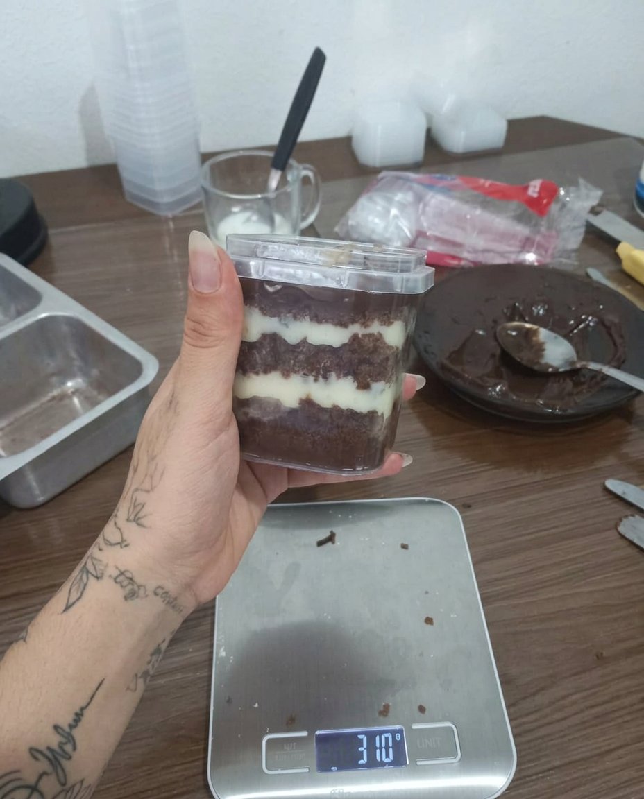 A close up view of a vanilla jar cake with colorful sprinkles and white frosting layers