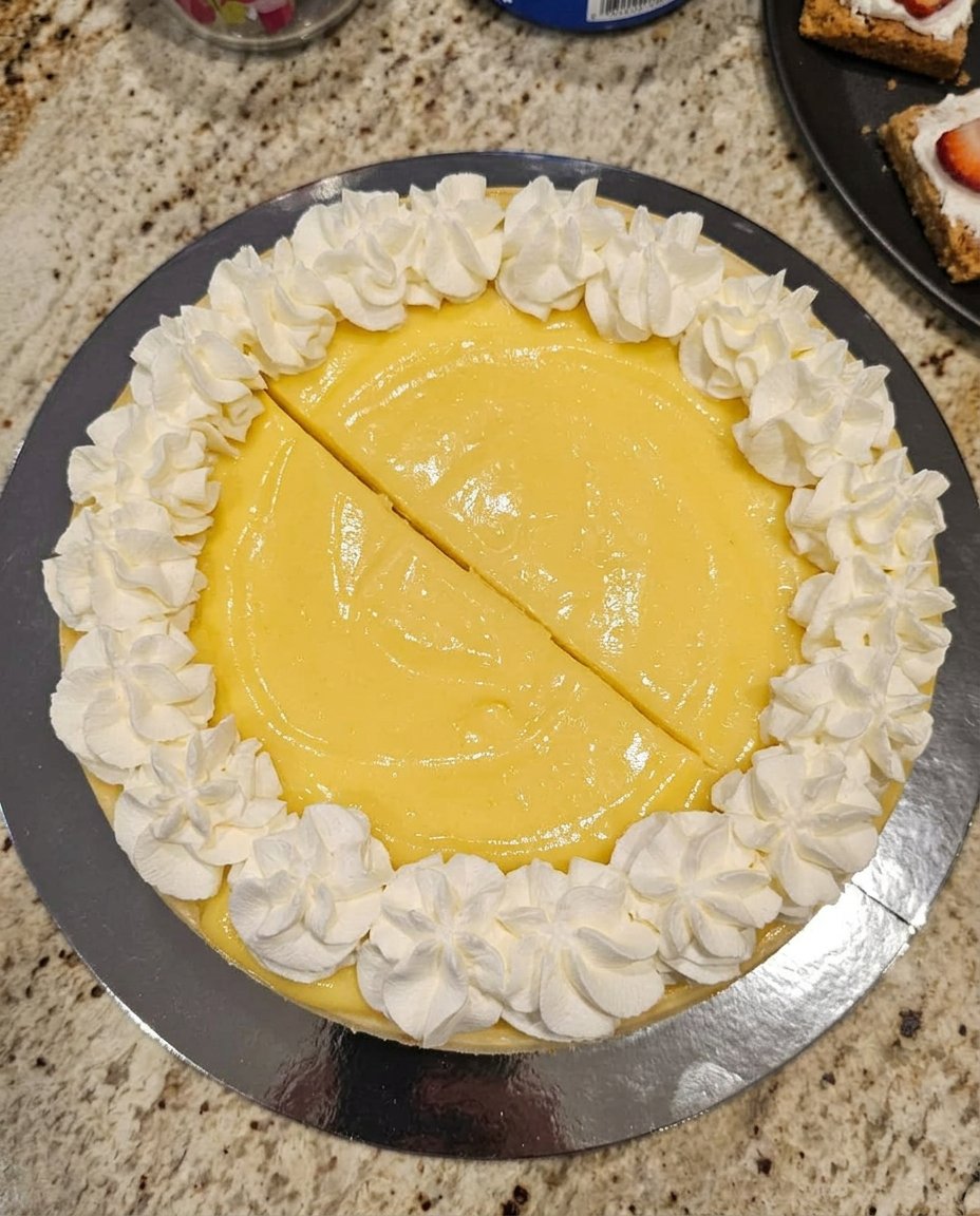 A slice of creamy lemon cheesecake on a vintage floral china plate with a silver fork