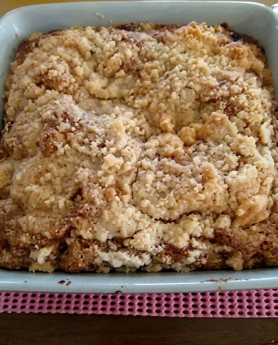 Strawberry Rhubarb Cake 14 A single slice of strawberry rhubarb cake on a floral plate with a melting scoop of vanilla ice cream.