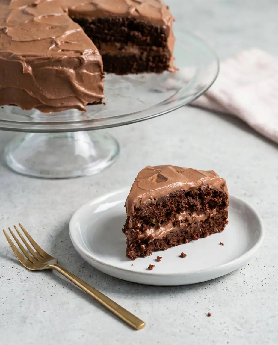 A perfectly cut square of Dairy-Free Chocolate Zucchini Cake served on a white china plate.