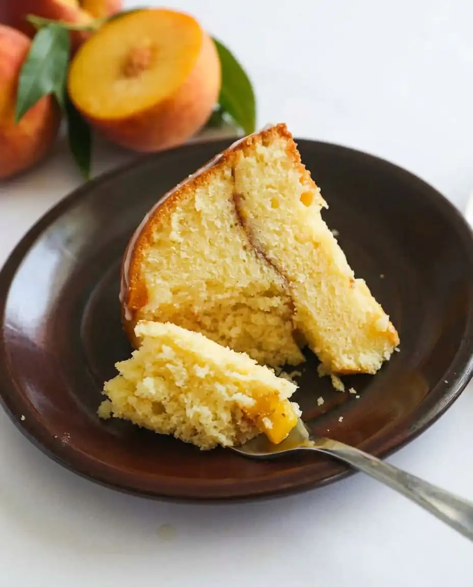 A Bundt pan being prepared with butter and a layer of cinnamon sugar and peaches