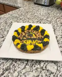 A golden brown chewy cookie cake resting on a vintage wire cooling rack with chocolate chips visible.
