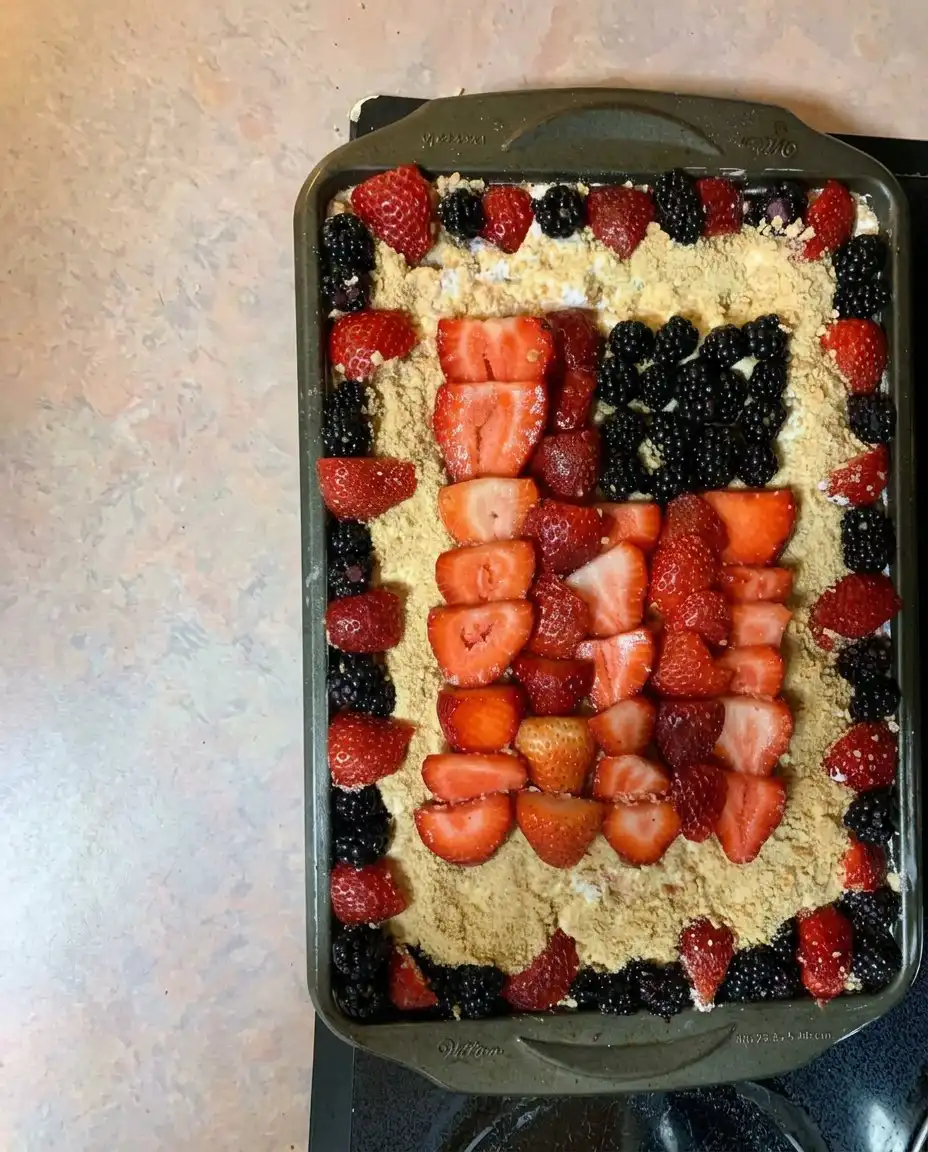 Perfectly chilled slice of mixed berry dessert showing distinct red, white, and blue layers
