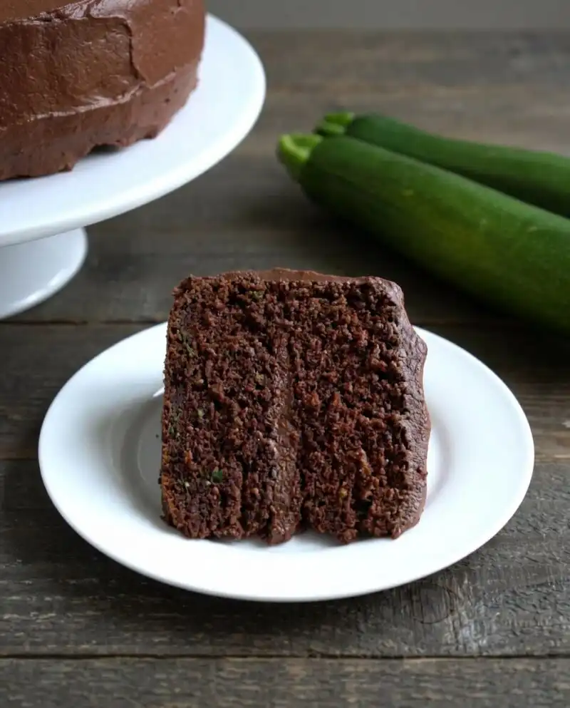 A moist chocolate lover's zucchini cake with dark chocolate frosting on a serving platter