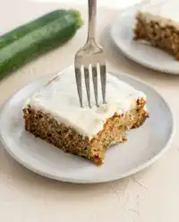 A Classic Zucchini Cake with Cream Cheese Frosting showing a thick layer of white topping.