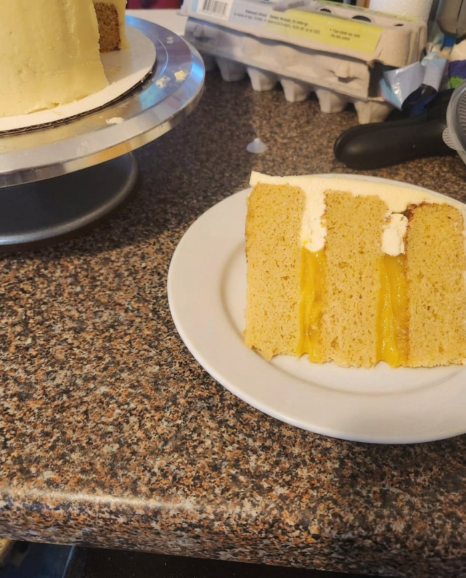 A close up shot of the thick and fluffy vanilla pudding frosting being spread onto the Orange Creamsicle Cake.