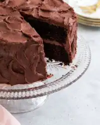 A rich and moist Devil's Food Layer Cake presented on a classic glass pedestal.