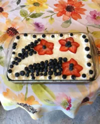 Overhead view of fudgy 4th of July brownies topped with cream cheese frosting and fresh berry firework designs