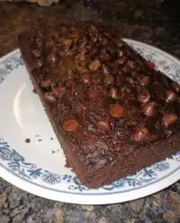 A whole loaf of chocolate zucchini bread resting on a wire rack