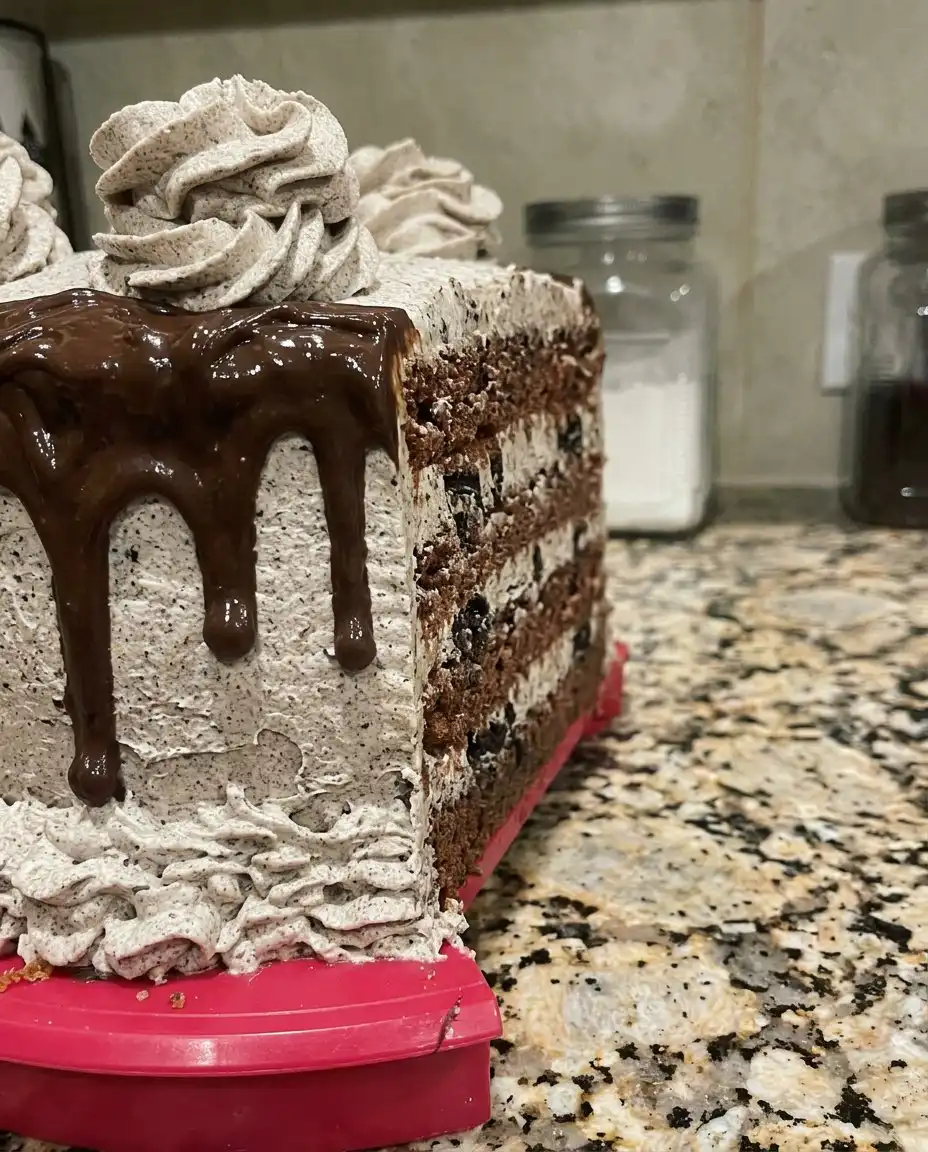 A single slice of Oreo cake on a white plate with a fork.