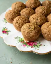 A close up shot of golden brown Banana Zucchini Muffins 2 resting on a wire cooling rack.