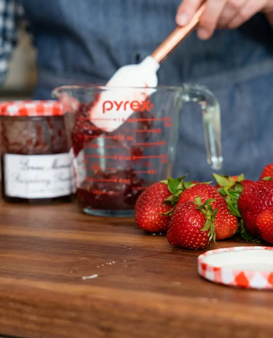 A vintage ceramic bowl filled with fresh strawberries, blueberries, and raspberries.