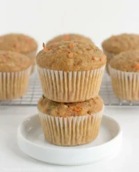 A close up view of freshly baked zucchini carrot oatmeal muffins resting on a cooling rack.