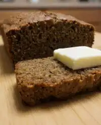 A golden brown apple zucchini bread loaf sitting on a cooling rack.