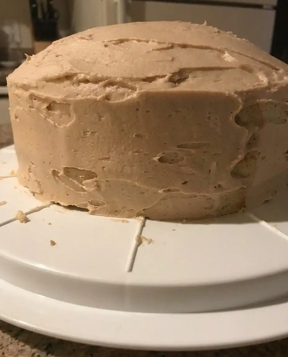 A single slice of peanut butter cake showing the moist crumb and thick frosting