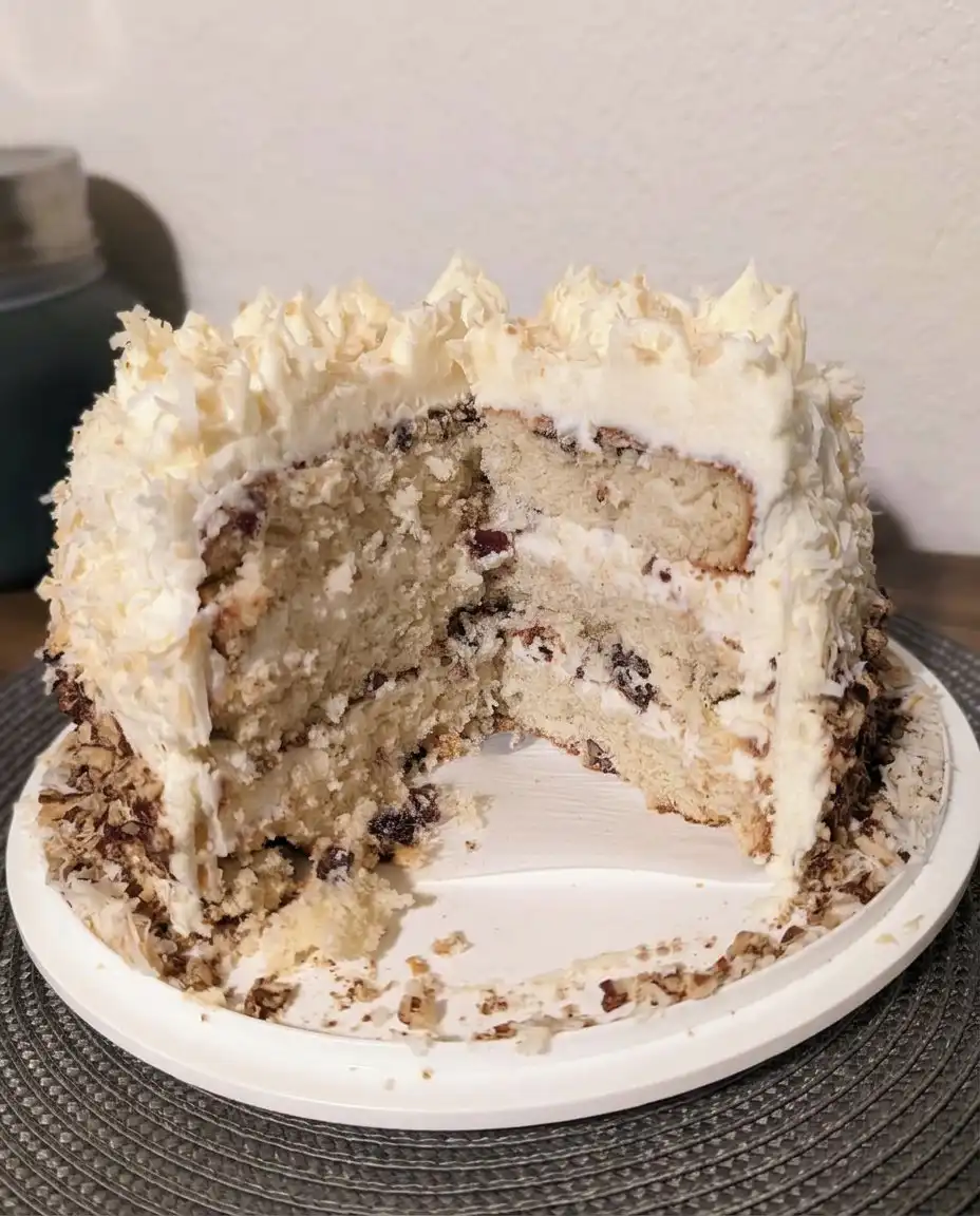 A close up of cream cheese frosting being spread on a cake layer