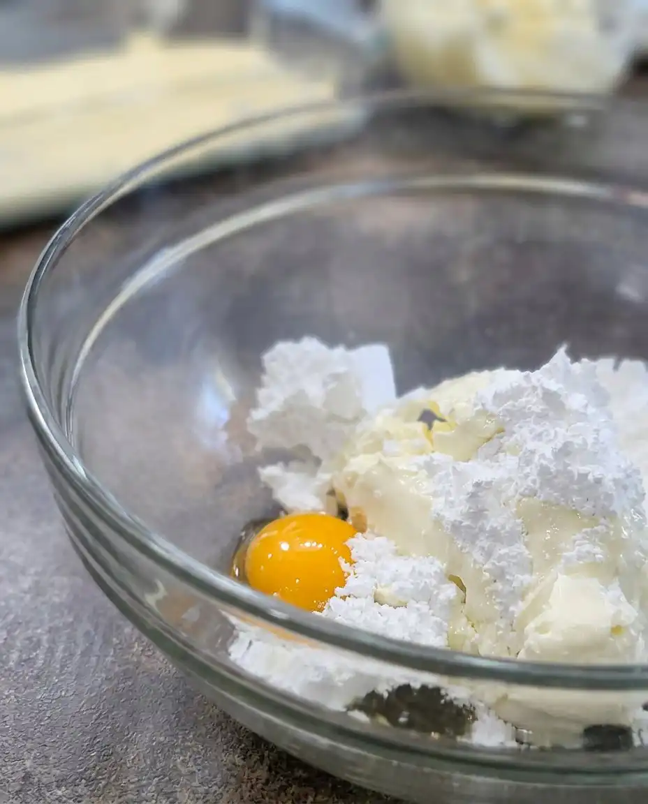 Ingredients for Peaches and Cream Bars including butter, peaches, and cream cheese in clear bowls.