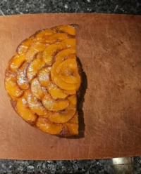 A close up slice of golden Ina Garten peach cake with fresh fruit chunks
