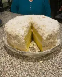 A slice of Italian Lemon Cream Cake with lemon zest and white chocolate curls