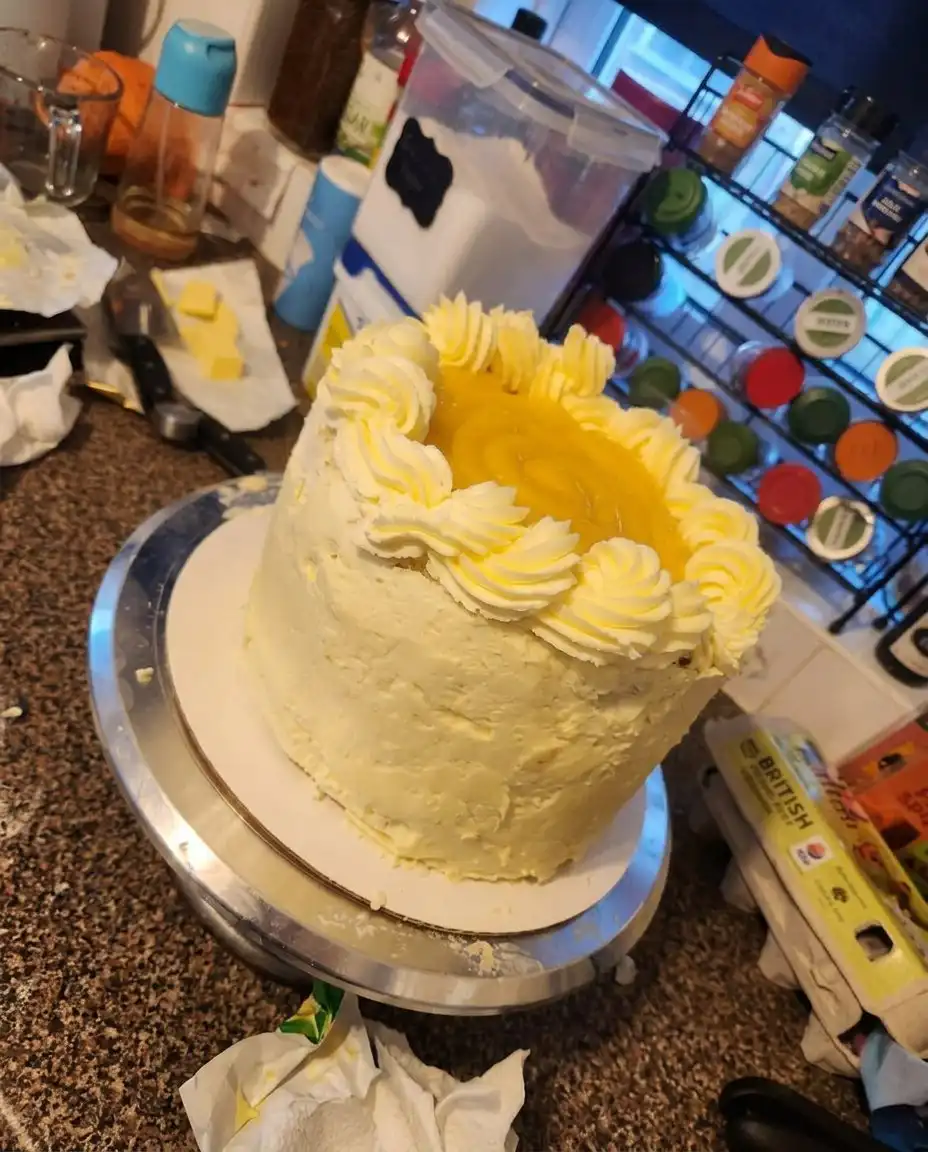 A single slice of Orange Creamsicle Cake served on a vintage floral china plate with a small fork.