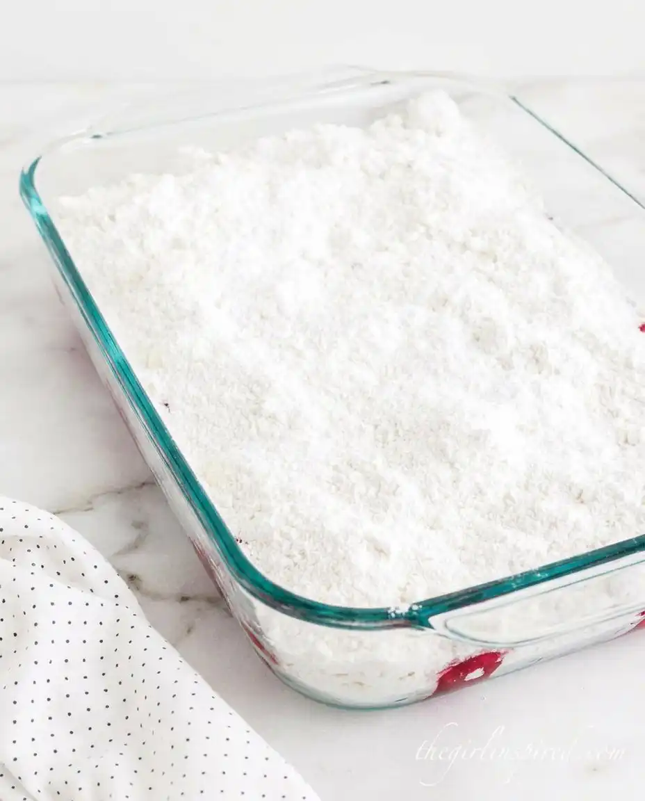 Cans of strawberry filling and cake mix on a wooden counter