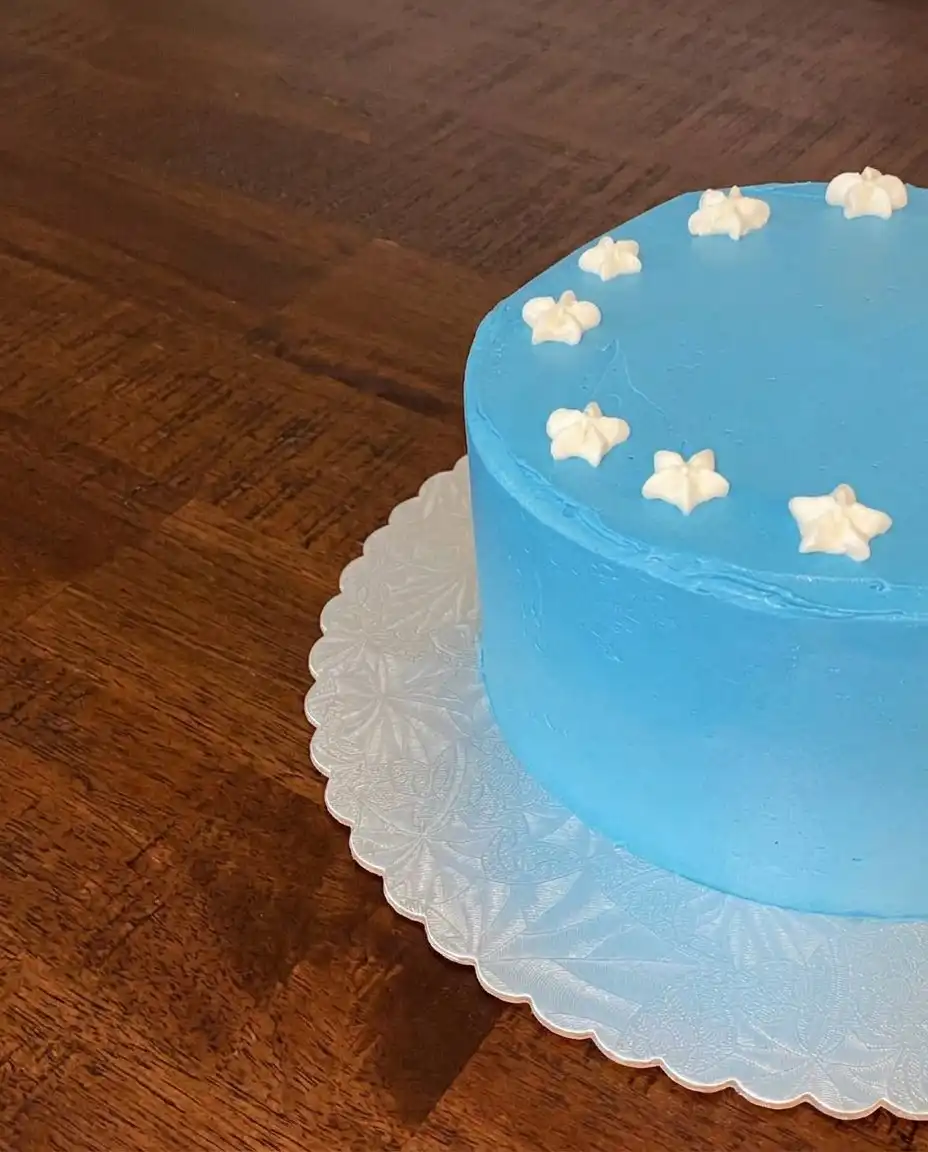 A slice of Red White and Blue Poke Cake showing red gelatin stripes on a vintage floral china plate.