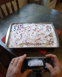 A close up cross section of a red white and blue patriotic poke cake showing the colorful gelatin infusions