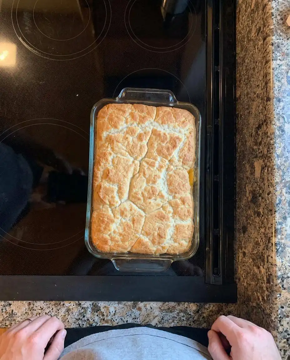 A serving of peach cobbler with a melting scoop of vanilla ice cream