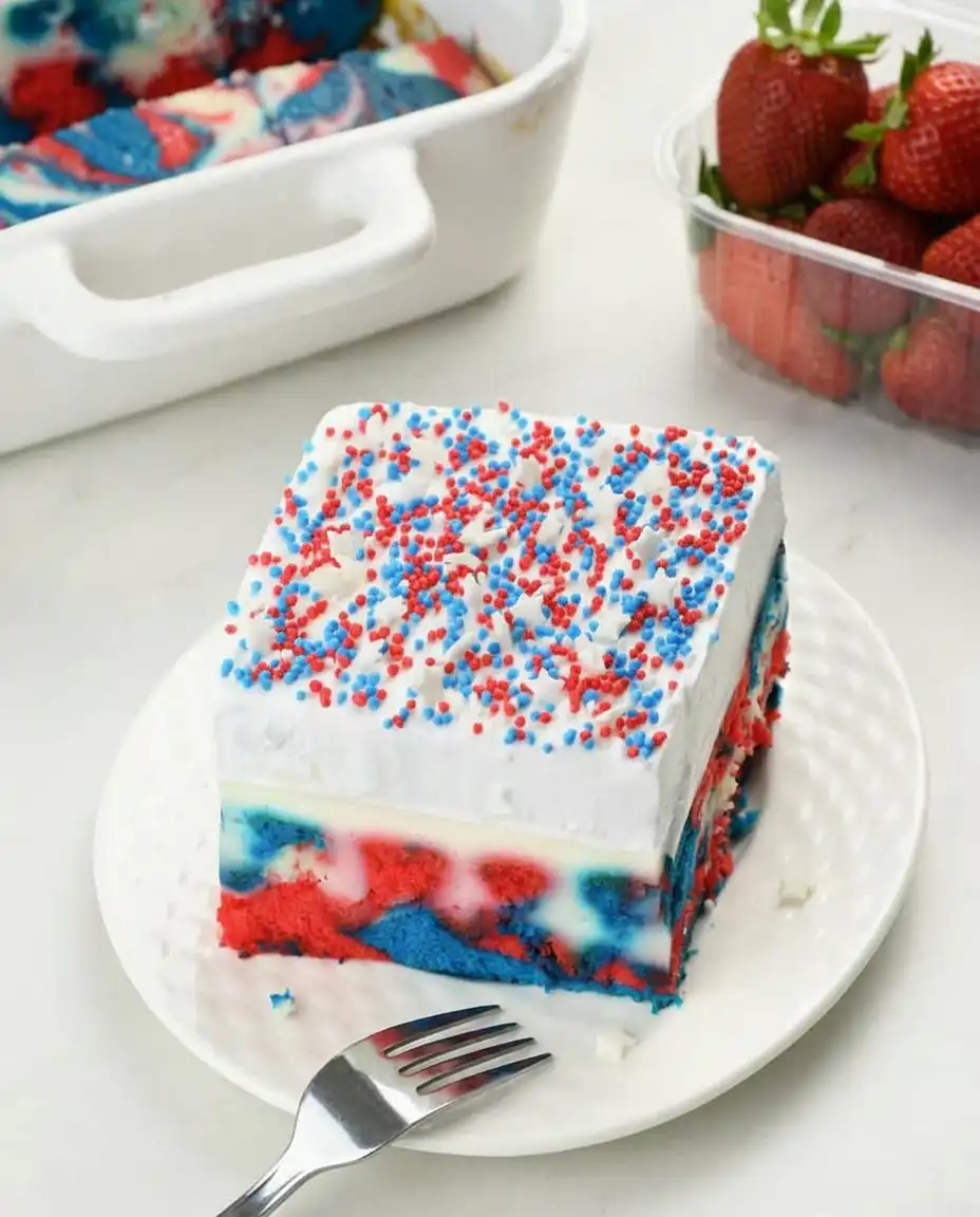 Using a wooden spoon handle to poke holes in a red white and blue cake