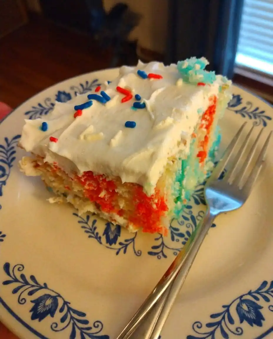 Hand using a straw to poke a grid of holes into a baked white sheet cake