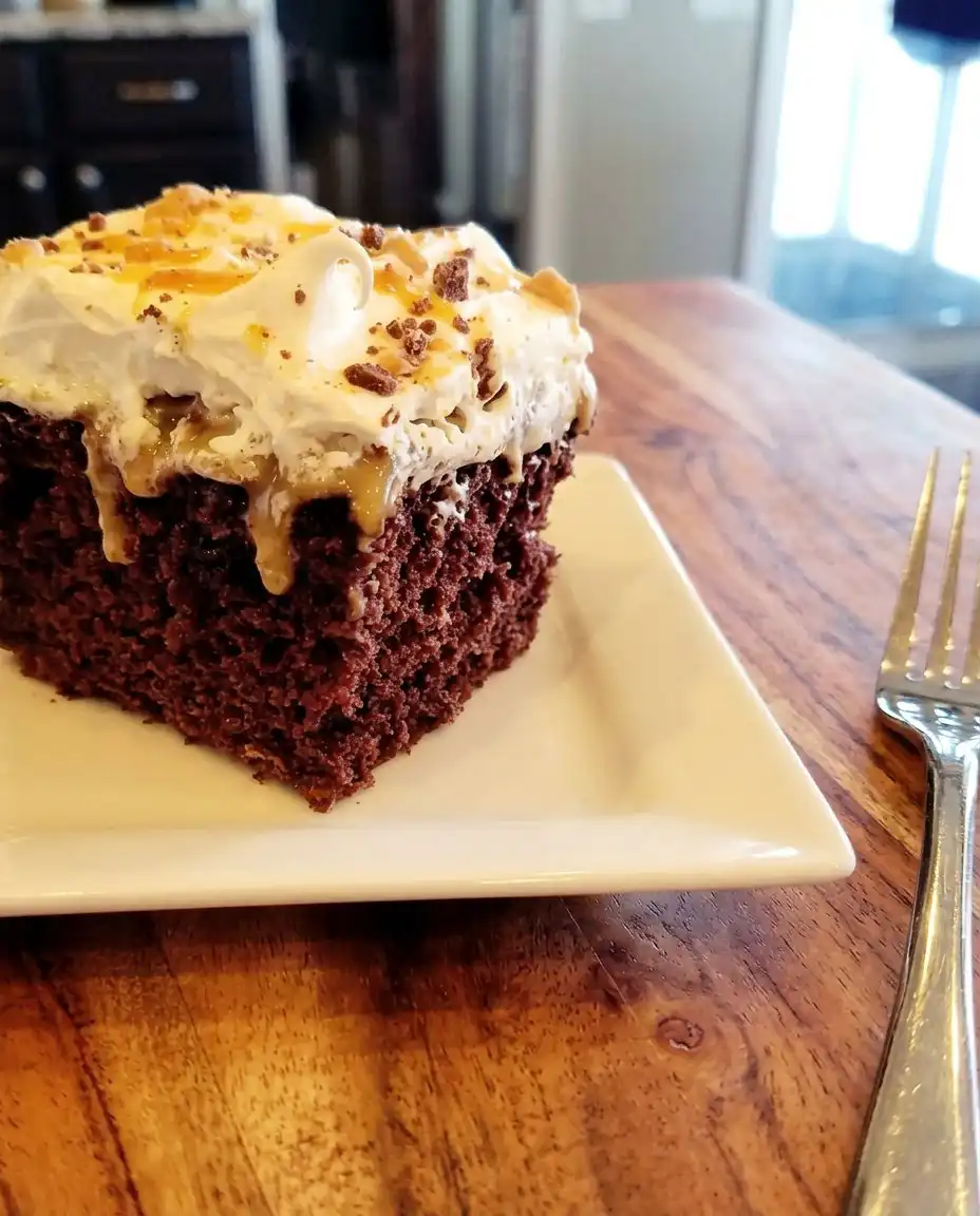 A hand using a wooden spoon to poke holes in a warm chocolate sheet cake