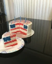 A slice of Red, White and Blue Layered Flag Cake showing the perfect internal flag design.