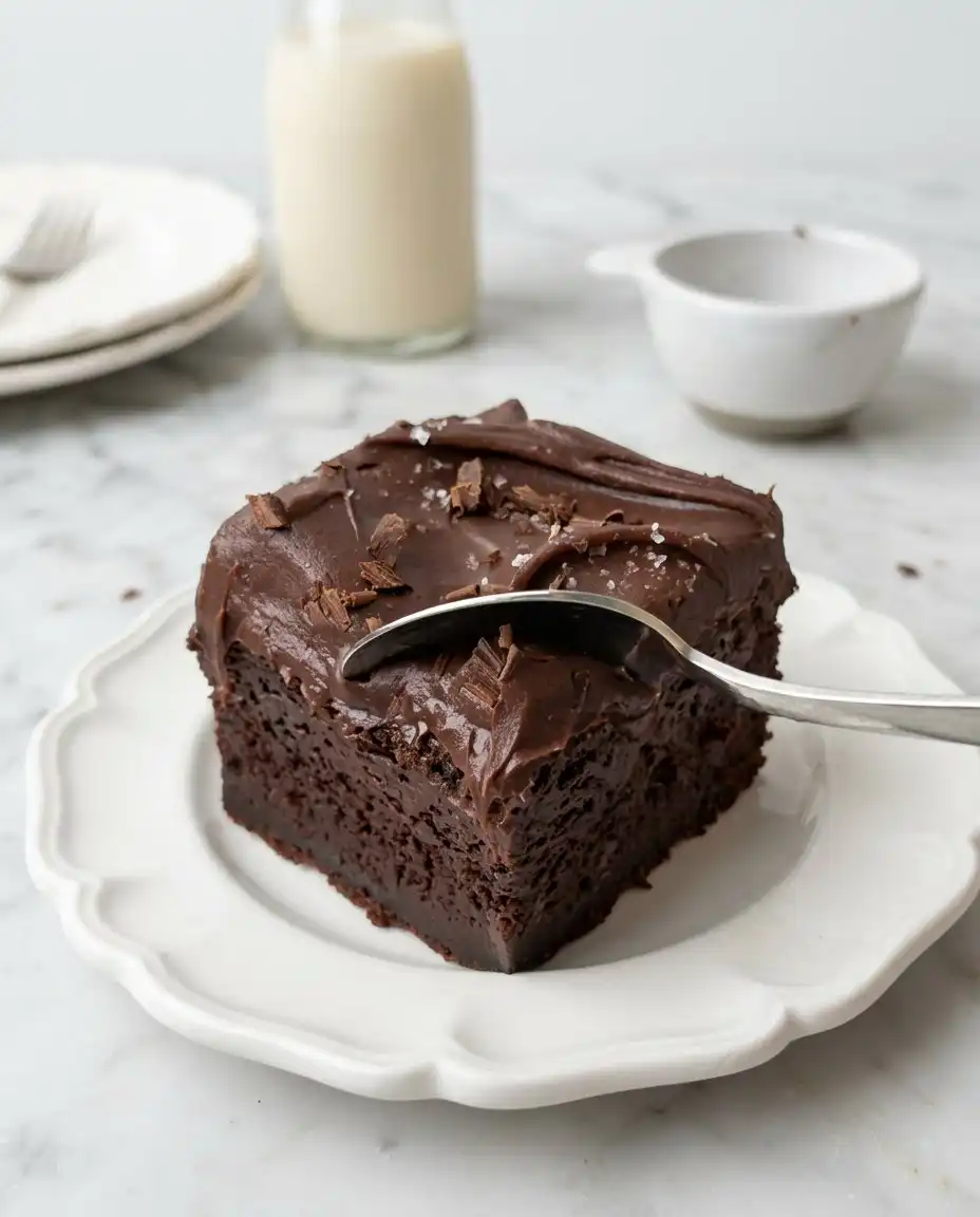 A whole Vegan Chocolate Zucchini Cake topped with dairy-free sour cream frosting.