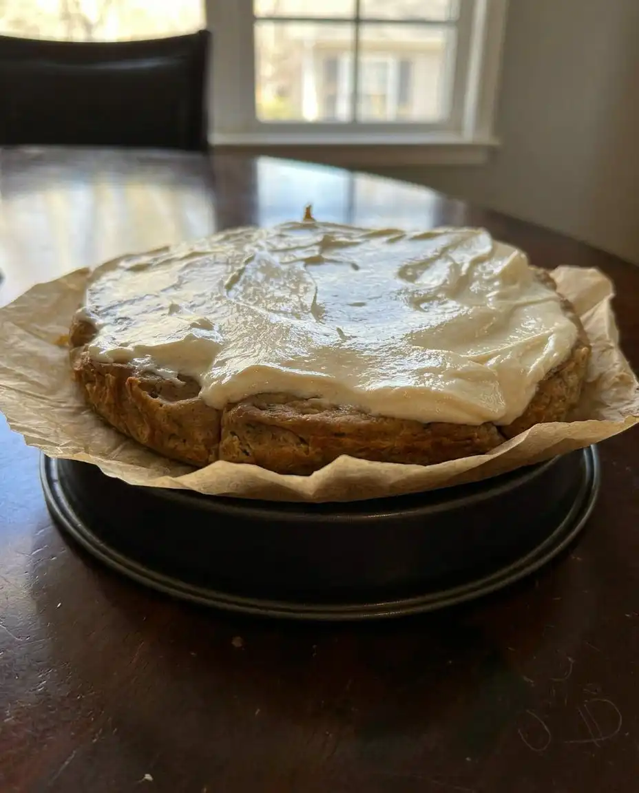 A slice of Moist Zucchini Banana Cake with maple frosting on a floral plate.