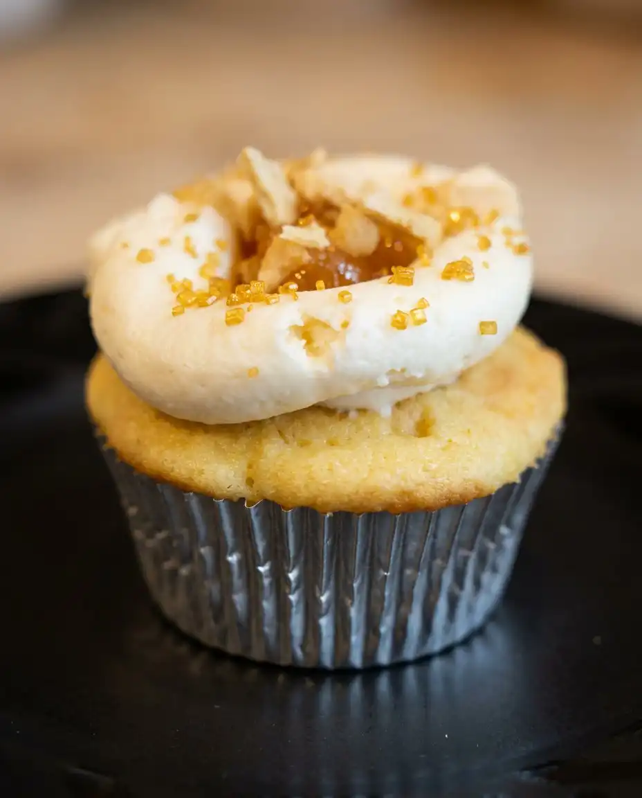 Three peach cheesecake cupcakes served on a vintage floral china plate with a silver fork.