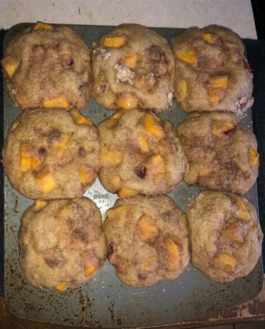 Peach cobbler muffins served on a plate with a cup of coffee